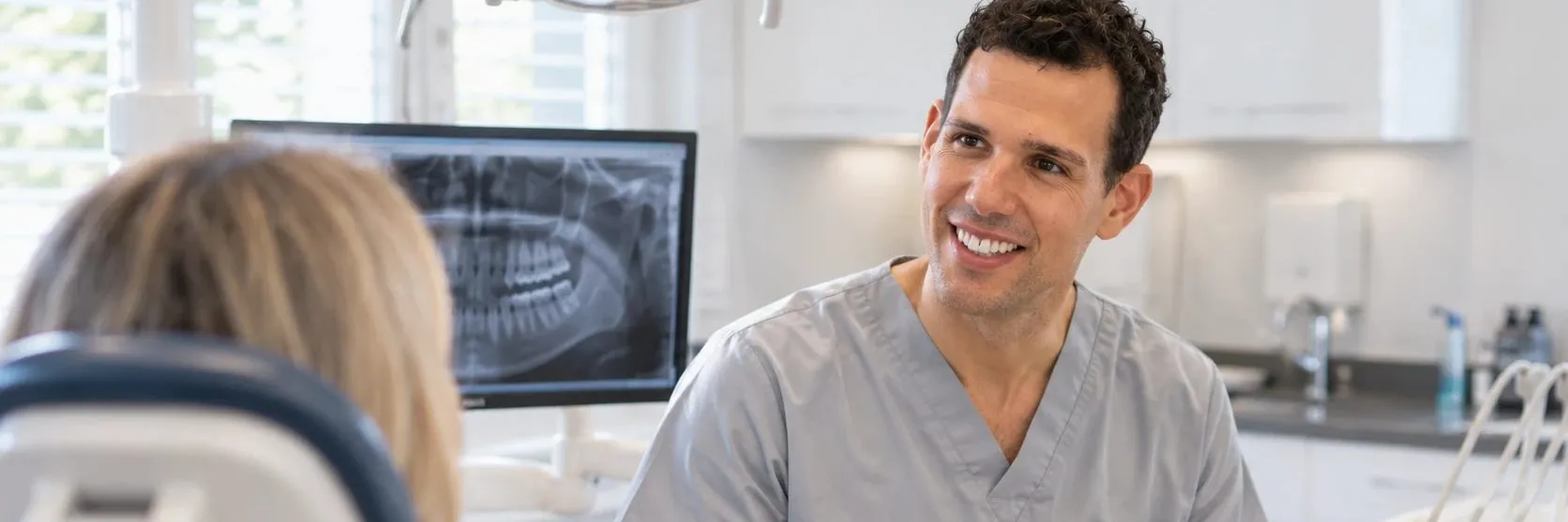 Dentist chatting with a patient in the surgery