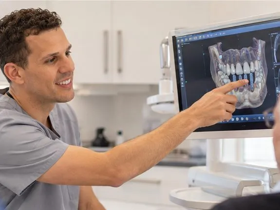 Dr Joao Souteiro pointing out a 3D scan to a patient