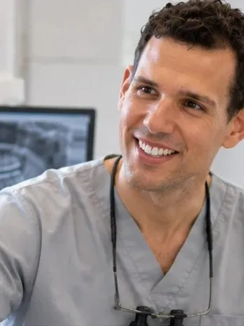 Dentist smiling while talking with a patient
