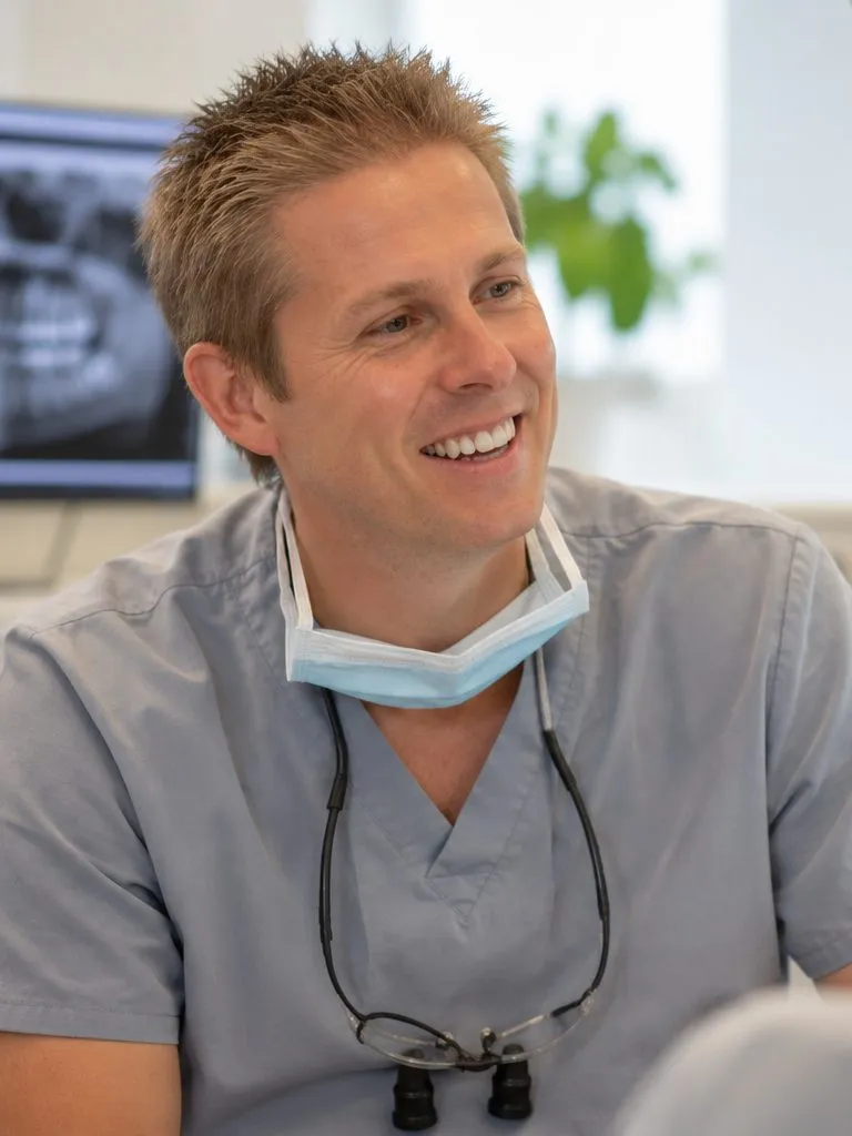 Dr Ross Cutts talking with a patient, with an X-ray on the screen behind