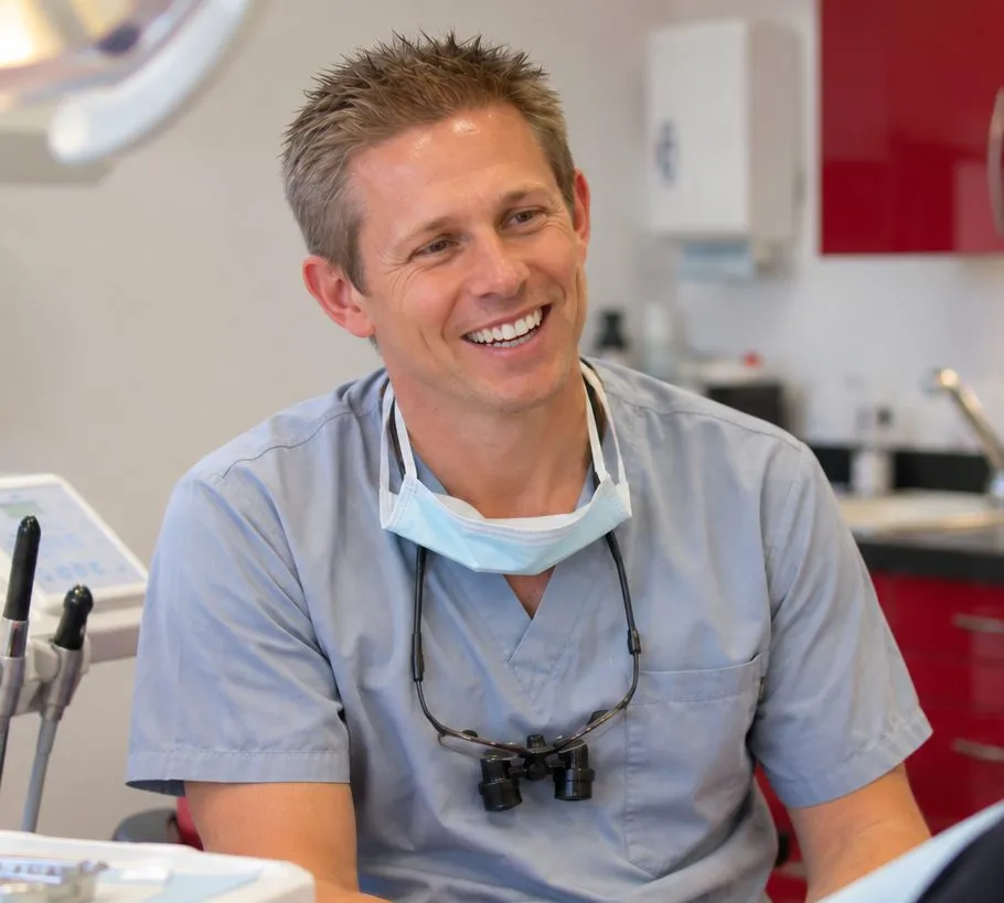 Dr Ross Cutts laughing in the treatment room, his mask pulled down