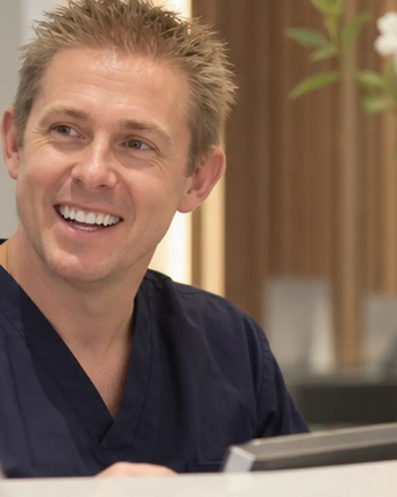 Dr Ross Cutts talking with a patient at the front desk