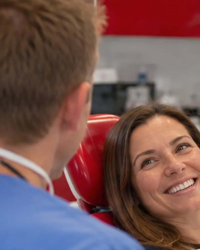 A patient in the dental chair smiling up at Dr Ross Cutts